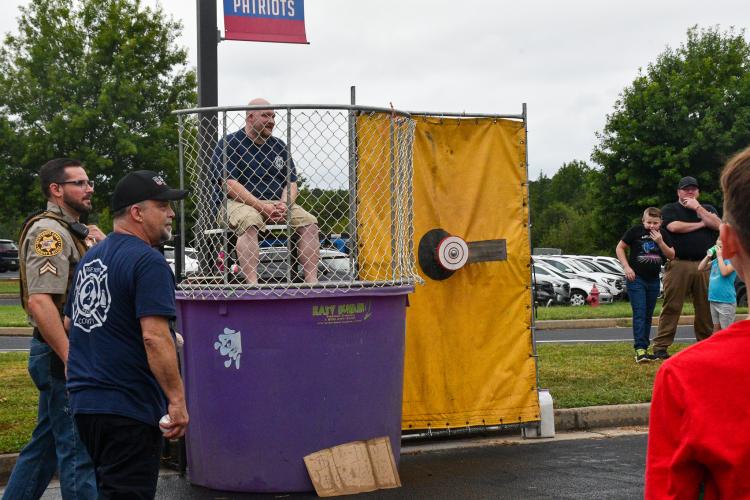 Oglethorpe County High School band director Lee Jones sits in the dunk tank waiting to get dunked at Community Day. Several of the attractions and vendors were outside, but the tables were inside the OCMS cafeteria for the second consecutive year. (Photo/Jennifer Xia)