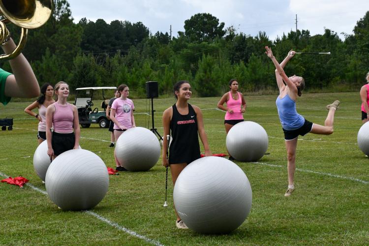 Senior majorette Peyton Lewis performs a solo surrounded by the auxiliaries during marching band practice on Thursday. (Photo/Jennifer Xia)