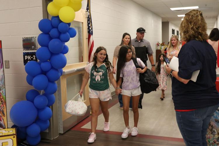 Students and parents are greeted by OCES teachers and staff Friday morning for the first day of school. Students were either dropped off at the car rider line, by school bus or were walked inside. (Photo/Anna Izquierdo)