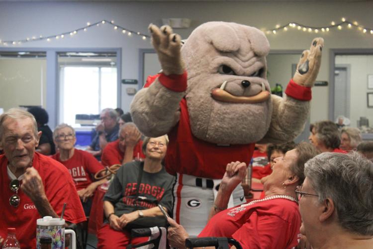 Hairy Dawg greets members of the Oglethorpe County Senior Center at their UGA tailgate party on Friday. The center also welcomed the UGA Dance Dawgs and cheerleaders. (Hannah Freeman/The Oglethorpe Echo)