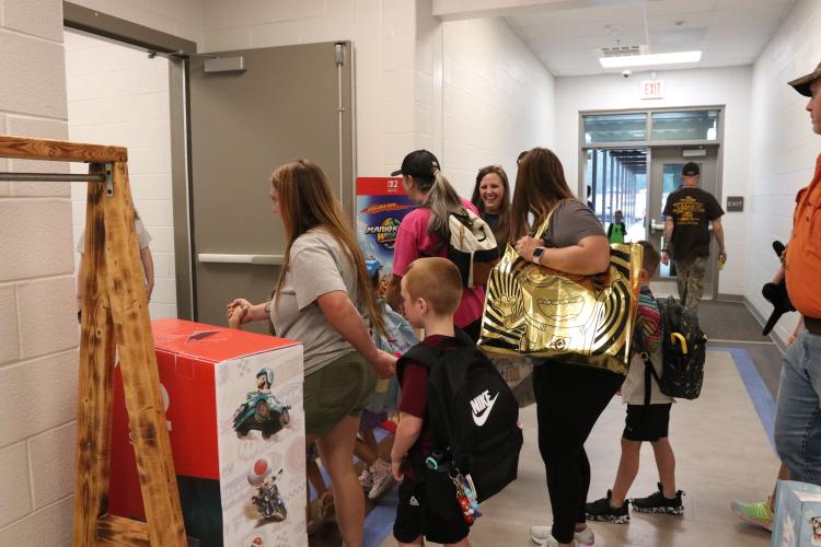 Melissa McGarity, who oversees the federal programs of the Oglethorpe County School System, greets students and parents in the pre-K through second grade hallway during the first day of school. This is the first full year for OCES, which opened in January. (Photo/Anna Izquierdo)