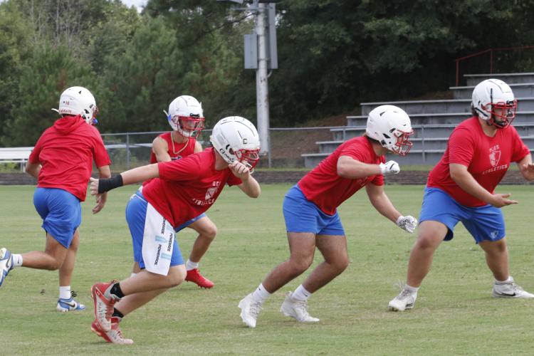 The offensive line works on blocking during practice last week. Center Brock Barrett (right), a senior, is the anchor of the line this year. (Photo/Andy Johnston)