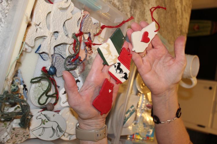 Tracy Massey holds four of her handmade ceramic Christmas ornaments at her home in Arnoldsville, Georgia on Aug. 28, 2025. Massey makes ceramic Christmas ornaments for herself and friends, selling them through Gallop and Glaze. (Photo/Emily Adams)