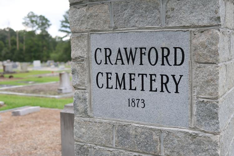 A stone sign marks the entrance of Crawford Cemetery, where the county’s new pauper's plot is located. The county voted in March to buy a plot there. (Katherine Davis/The Oglethorpe Echo)