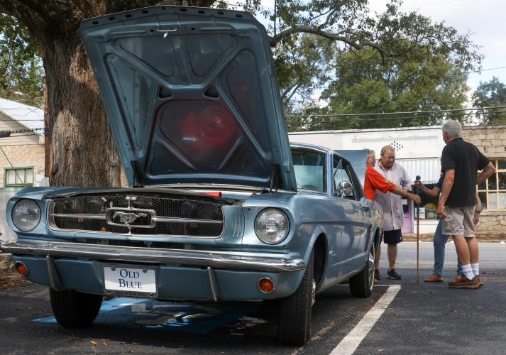 David Lowe of Good Hope shows attendees his handmade walking sticks in the trunk of his 1965 Ford Mustang named "Old Blue" at the Firefly Cruise-In in Lexington, Georgia on Sunday, Sept. 28, 2025. Lowe and his wife, Cindy, also have an antique truck named "Big Red." (Photo/Susanna Johnson)