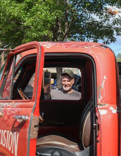 Talking to another attendee, Randy Suttles of Elberton looks through the window of his 1955 Chevrolet truck at the Firefly Cruise-In in Lexington, Georgia on Sept. 28, 2025. Suttles owns an auto shop out of Bowman called Precision Paint and Body. (Photo/Susanna Johnson)