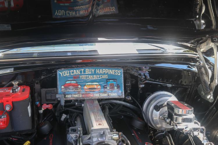 A sign sits in the engine of a vehicle at the Firefly Cruise-In in Lexington, Georgia on Sept. 28, 2025. The event served as a setting for vintage car collectors and fanatics to share their passion with other locals. (Photo/Susanna Johnson)