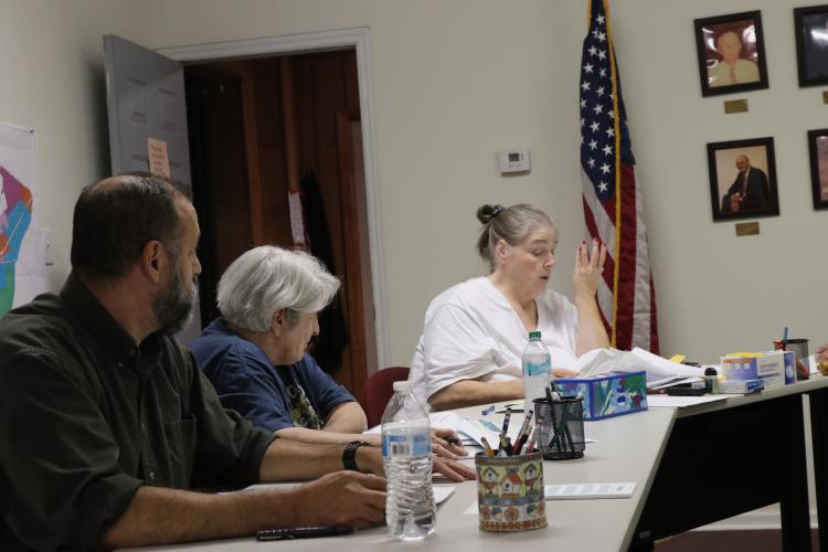 Crawford City Clerk Amy Wall-Lance (right) discusses the meeting agenda to the city council on Oct. 14. Willie Torres (left), who recently replaced Sandra Sheridan as a council member, and Brenda Butler (middle) listen to Wall-Lance. (Ansley Gavlak/The Oglethorpe Echo)