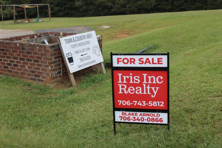 A for sale sign sits in the front yard of Town and Country Kafe on Friday, Sept. 26, 2025 in Crawford, Georgia. The restaurant, owned by Willie Torres and Amy Delfin-Torres, has been on the market for two weeks. (photo/Emily Adams)