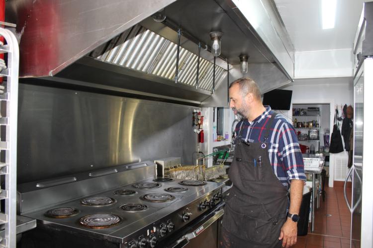 Willie Torres describes all the pieces that make up the commercial kitchen at Town and Country Kafe on Friday, Sept. 26, 2025 in Crawford, Georgia. The kitchen is used by head chef, Amy Delfin-Torres, and is fully equipped for a new restaurant to open in the space. (photo/Emily Adams)