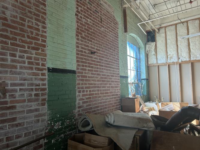 The upstairs of the factory building was partially insulated for an apartment, and part of it has exposed brick walls and large windows. This is part of the Historic Jefferson Mill property in Crawford that went up for sale in October of 2025 for $1.6 million. (Makenna Reavis/The Oglethorpe Echo)
