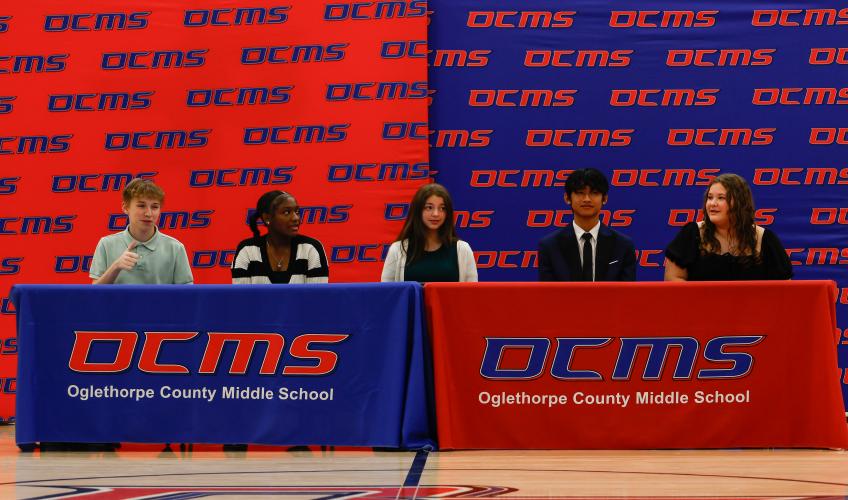 All five REACH Georgia scholars (Silas Judson, Nevaeh Perry, Elizabeth Randolph, Eh Way,  Haleigh York) sit at the signing table before finalizing their contracts on Friday, Nov. 14, 2025. The ceremony represents the culmination of a months-long selection process. (Photo / Drew Bearden)