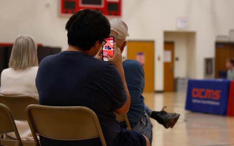 A family member takes a photo as Eh Way signs her REACH Georgia Scholarship contract on Friday, Nov. 14, 2025. The moment marks the start of a new chapter supported by mentorship and financial assistance. (Photo / Drew Bearden)