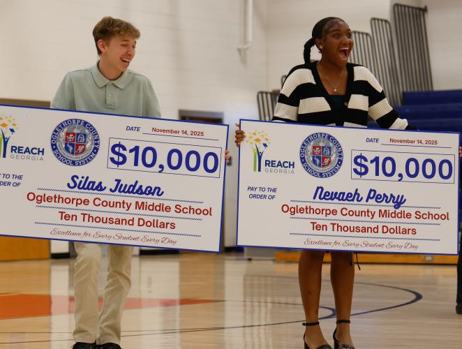 Silas Judson and Nevaeh Perry smile as they hold their REACH Georgia checks on Friday, Nov. 14, 2025. Both students said the scholarship expands their college possibilities. (Photo / Drew Bearden)