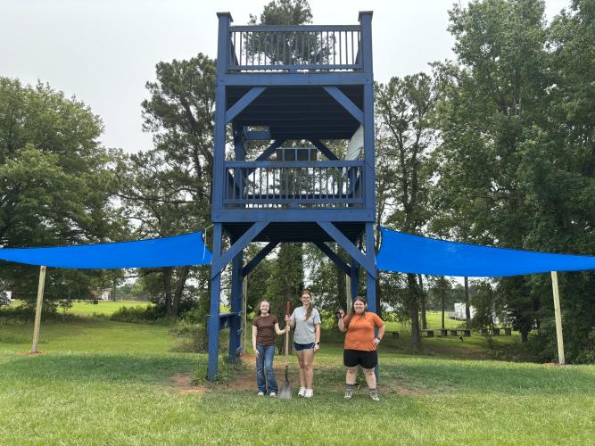 Kassie Mathews (from left), Alexis Brakhage and Madelyn Flores stand in front of the Eagle Scout project, sun shades for the Oglethorpe County marching band. Flores is the second female in the county to earn the prestigious honor. (Submitted Photo)
