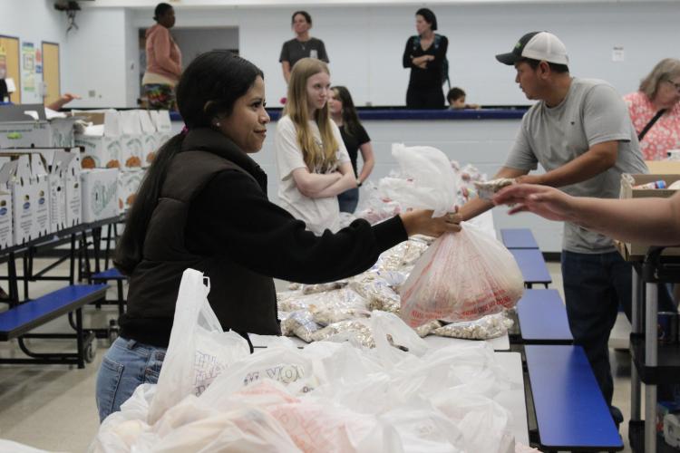 Pricila Salas-Lopez, a junior at OCHS, hands out bags of onions to families at the high school food pantry on Nov. 20. Salas-Lopez began volunteering for the pantry because she loves helping people. (Hannah Freeman/The Oglethorpe Echo)