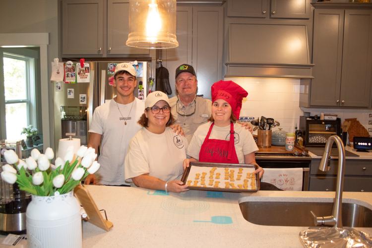 The Marler family smiles while holding Izzy’s fresh batch of dog treats. The family moved from Florida to Winterville in 2022. (Grace Burnett/The Oglethorpe Echo)
