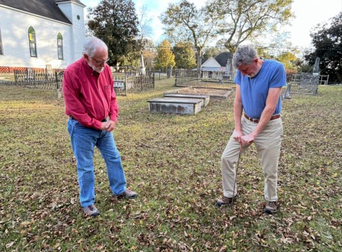 Ronnie Boggs (left) looks on as Tom Gresham uses a soil probe at Beth-Salem Presbyterian Church and cemetery last week. The probe helps determine whether a burial may be present in a specific location. (Photo/Molly Moore)
