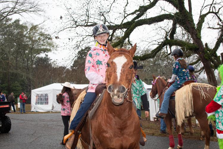 Marlee Waldroup and her horse both smile for the camera after the Maxeys Christmas Parade. The Echo Hill Farm horses wore Hawaiian skirts, and riders wore tropical shirts and leis, adding a twist to typical Christmas attire. (Grace Burnett/ The Oglethorpe Echo)