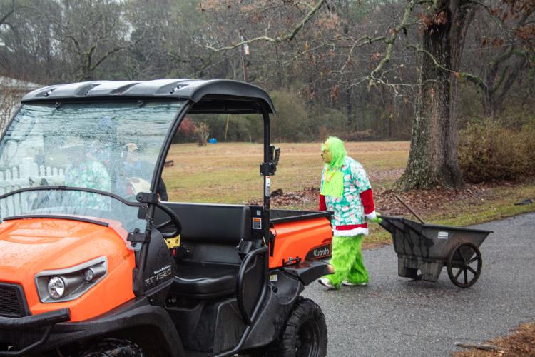 The Grinch follows behind the Echo Hill Farm horses in the parade and wears a shirt with a sign saying “I hate horses!” Parade attendees enjoyed the Christmas spirit, despite the Grinch’s negative attitude and the cold weather. (Grace Burnett/The Oglethorpe Echo)