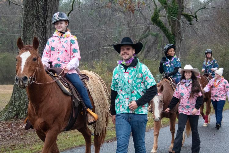 The Echo Hill Farm crew and riders, Marlee Waldroup, Skye Spade and Aubrey Wisham, celebrated Christmas the tropical way through their Hawaiian Christmas shirts and leis. After Echo Hill Riders’ first parade, they receive a tiara on their helmet. (Grace Burnett/ The Oglethorpe Echo)