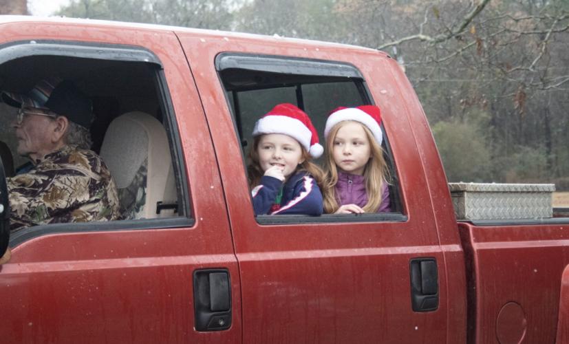 Bobbie (left) and Karlie Hathcock (right) watch the parade floats and other sights as Gary Bird drives the truck that pulled the Redcoat alumni band throughout the seventh annual Maxeys Christmas Parade on Saturday. (Grace Burnett/ The Oglethorpe Echo)
