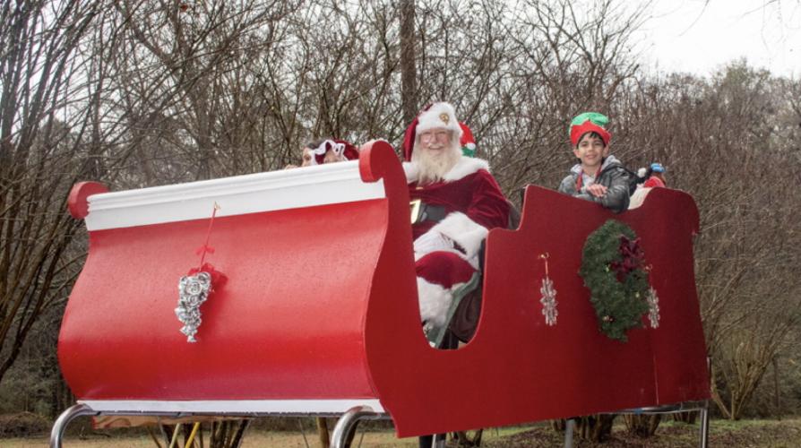 Santa Claus, Mrs. Claus and an elf ride on a float that looks like a sleigh as they take part in the seventh annual Maxeys Christmas Parade on Saturday. Santa Claus closed out the parade and stayed for pictures with families. (Grace Burnett/ The Oglethorpe Echo)