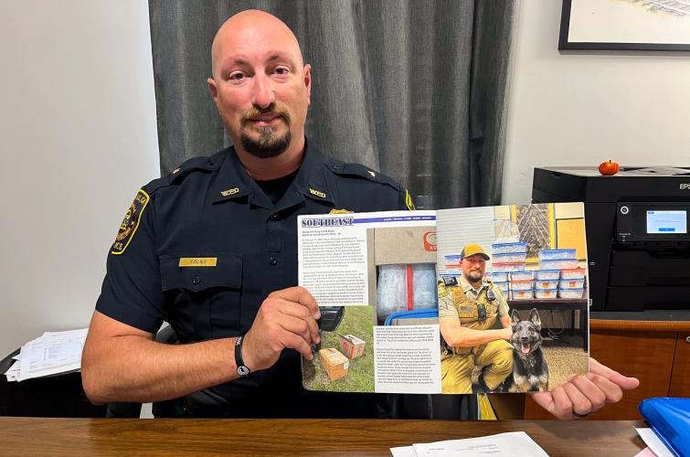 Colt Young, Winterville’s chief of police and a former K-9 officer, holds a magazine featuring an article about him and his former K-9 partner, Roni, at the Winterville Police Department this fall. The story highlights their role in a large methamphetamine raid. (Gabrielle Gruszynski/The Oglethorpe Echo)