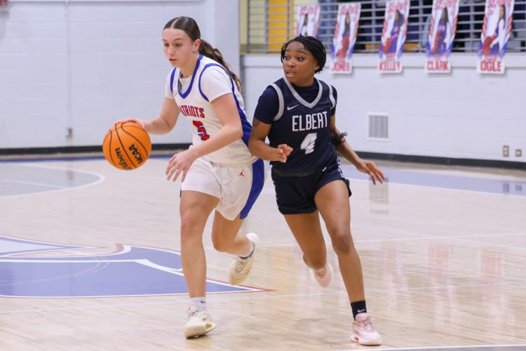 Oglethorpe County player Marin Sampson dribbles the ball past Elbert County player Kaylen Rucker on Feb. 10. The Patriots lost to the Blue Devils with a score of 40-58. (Photo/Addison Simmons)