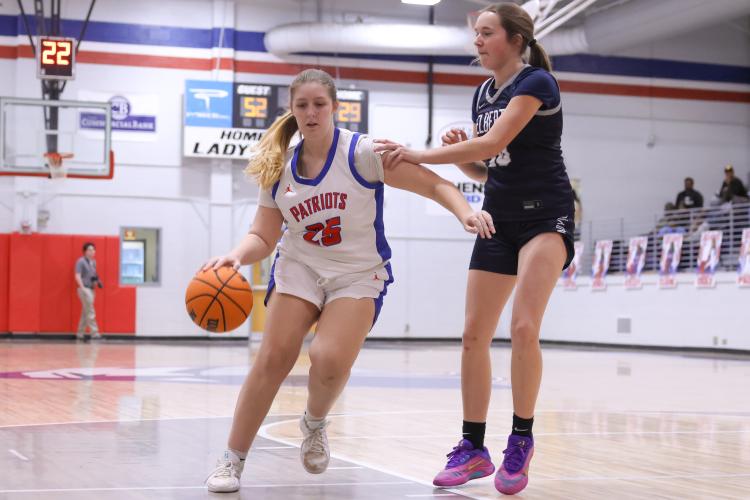 Oglethorpe County senior Ansley Paul dribbles the ball past Elbert County player Ella Harris on Feb. 10. The Patriots lost to the Blue Devils with a score of 40-58. (Photo/Addison Simmons)