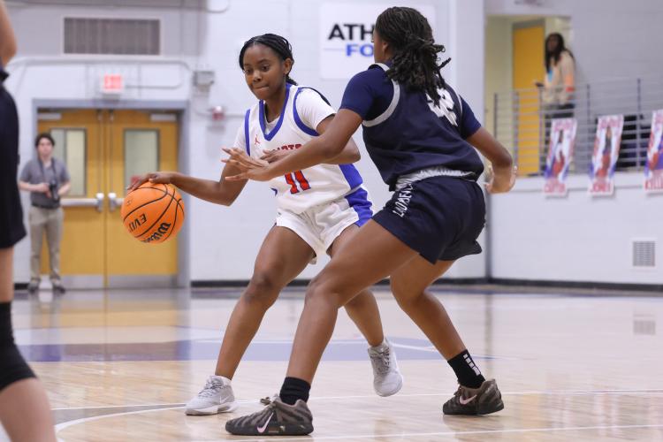 Oglethorpe County player Jaliyah Glenn dribbles the ball past Elbert County player Autumn Davis on Feb. 10. The Patriots lost to the Blue Devils with a score of 40-58. (Photo/Addison Simmons)