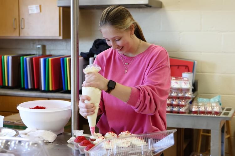 Emilee Cutsail ices red velvet cupcakes for the CAYA House's annual Valentine's Day fundraiser on Friday, Feb. 13, 2026, in Lexington, Georgia. 2026 marks the fundraiser's fourteenth year since its start in 2012. (Photo/Sydney Shankman)