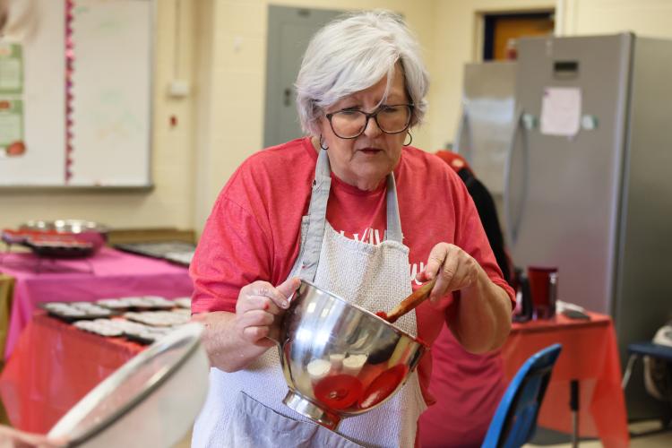 Jo Harrison transfers completed cupcake batter into a bowl for the CAYA House annual Valentine's Day fundraiser on Friday, Feb. 13, 2026, in Lexington, Georgia. Every year, Harrison has returned to help her daughter, Jill Kort, bake cupcakes. (Photo/Sydney Shankman)