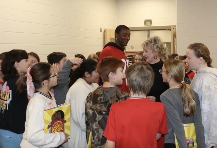 Oglethorpe County Elementary School students surround Malcolm Mitchell, author and former UGA and NFL receiver, while holding his book “My Very Favorite Book in the Whole Wide World” on Feb. 4. Many students wanted to talk to Mitchell or asked him to sign their books or clothing. CHARLOTTE COCHRAN/THE OGLETHORPE ECHO