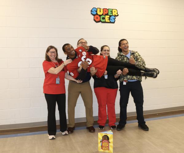 OCES gifted teacher Lindsay Gregory (from left), STEM teacher Kevin Southall, media specialist Corrie Mattox and art teacher John Lutz hold Malcolm Mitchell. Both students and teachers requested photos with Mitchell. (CHARLOTTE COCHRAN/THE OGLETHORPE ECHO)