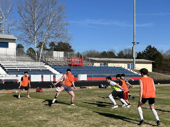 GRANT TURNAGE/THE OGLETHORPE ECHO Coach Brandon Thixton divided his OCHS boys team into two squads to work on passing and communication in tight spaces during a recent practice. The orange team, led by Clint Graham, competed in a drill called over “the river.”