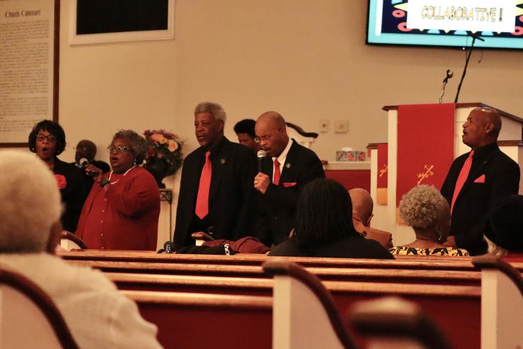 Deacon Dennis Robinson leads a rendition of  "Wade in the Water," a traditional African American spiritual rooted in slavery. Music played a key role in the Inaugural Black History Collaborative's celebration of Black History Month on Sunday. (Photo/ Mia Tanner)
