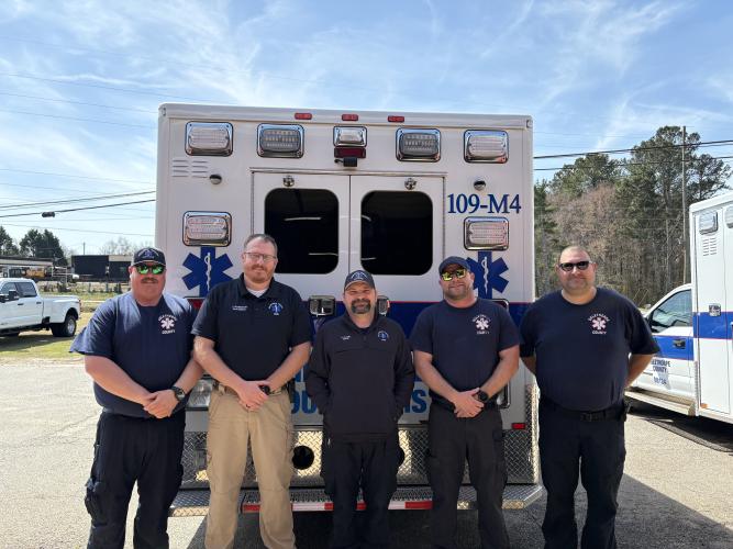 An Oglethorpe County EMS team, including medical technician Kelly Huff (from left), director Josh Robinson, EMT Jeffrey Clark, EMT Roy Allen and supervisor paramedic Dennis Weaver, stand in front of an ambulance on April 21, 2025. Robinson said EMS will be hosting a gathering of past and present employees in the fall to celebrate the service's 50th anniversary. (Photo/Emery Pikel)
