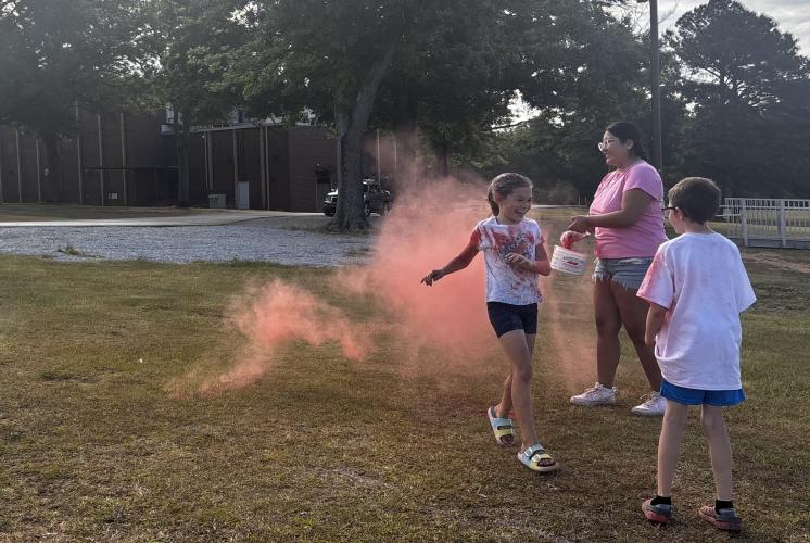 Kennedy McNair finishes the OCHS National Honor Society Color Fun Run with a smile as Yadhira Moreno, OCHS student volunteer, throws red powder on her. “This is another way that we try to have students connect with their community, and give back,” said Jennifer Yauck, a science instructional coach and NHS adviser at OCHS. (CHARLOTTE COCHRAN/THE OGLETHORPE ECHO)