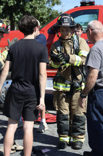 Students try on firefighter gear during the annual Ghost Out event at Oglethorpe County High School on April 17. The pre-prom program featured hands-on activities with local emergency services to promote road safety and awareness. (Photo/Kira Doppel)