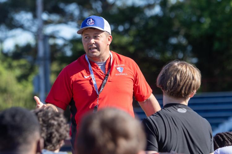 Oglethorpe County football head coach Mike Holland speaks with players after practice at Oglethorpe County High School in Lexington, Georgia, on Friday, May 15, 2026. Pass, a senior, plays alongside his sophomore brother, Zion. (Ethan Greene/The Oglethorpe Echo)