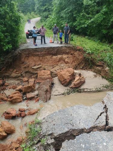 Several people take a look at the damage to Emerald Green Drive caused by heavy rains in the county the past week. About 30 people were stranded on one side of the dead-end road. (Photo/Submitted)