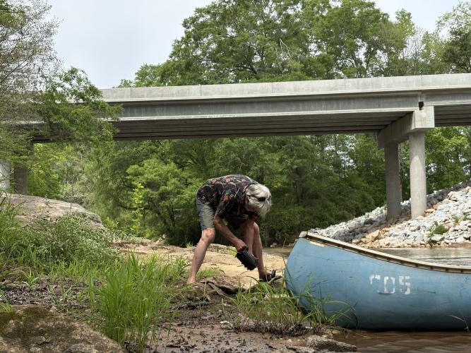 Michael Moody plants a shoal lily into the riverbank of the Broad River on Apr. 13 2026. (Dakota Meeks/The Oglethorpe Echo)