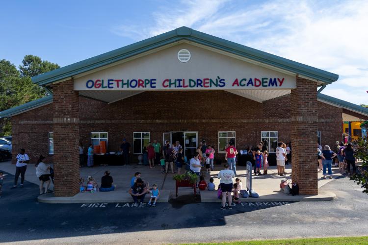 Families and staff gather at Oglethorpe Children's Academy in Crawford on Friday for OCA's 20th anniversary celebration. Attendees enjoyed food trucks, pizza, a photo booth and bouncy houses. (Ethan Greene/The Oglethorpe Echo)