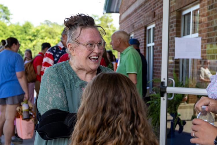 Oglethorpe Children's Academy founder and owner Melanee McGee talks with a family at OCA's 20th anniversary celebration. Many alumni also came to the event. “Somebody I used to carry in my arm or on my hip or snuggle with is now so big that all I can do is wrap my arms around and hug,” McGee said. (Ethan Greene/ The Oglethorpe Echo)