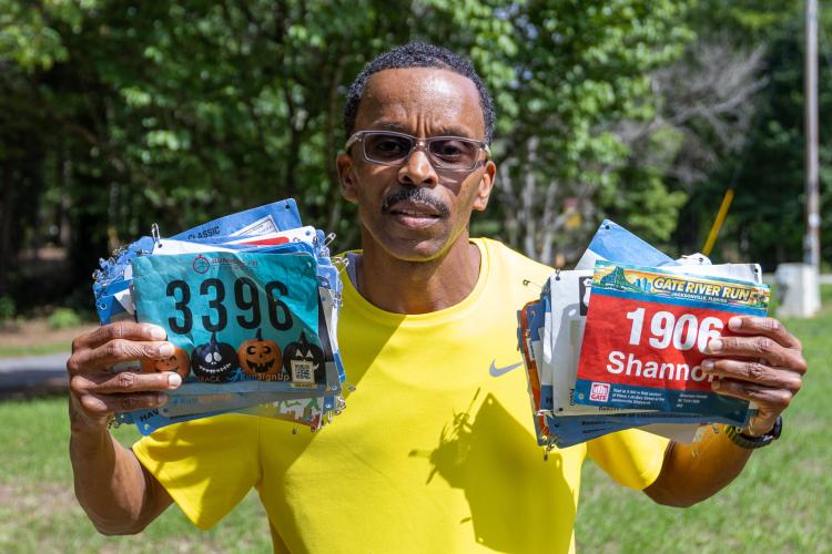 Crawford resident Shannon Arnol holds up some of the many running bibs he’s collected during three years of races. Arnold placed third in the Maxeys Model Mile 5K in May and will compete in the National Senior Games in Tulsa, Oklahoma in July. (Ethan Greene/The Oglethorpe Echo)
