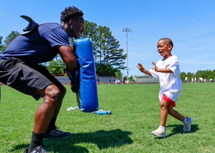 Jayden Allen, a staff member for the Bonds Movement Youth Football Camp, does a blocking drill Saturday with Milan Rucker on the football field. Parent Kayla Gravely said the staff is what drew her to send her two sons back to the camp for their second year. “The way (the staff) step in, and the way the interaction is with all the kids — it's great,” she said. (Ethan Greene/The Oglethorpe Echo)