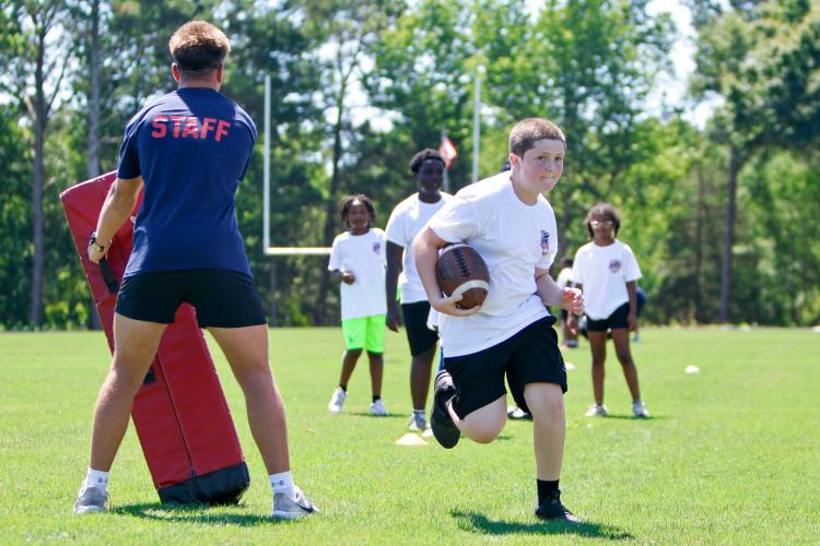 Campers compete in a drill, helped by former OCHS running back Jake Turner, during the second annual Bonds Movement Youth Football Camp at Oglethorpe County High School in Lexington on Saturday. The camp is organized by former OCHS football player KB Bonds, who graduated in 2022. (Ethan Greene/The Oglethorpe Echo)