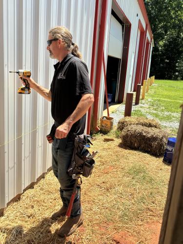 Christopher Allen, a foreman at Ethan Allen Enterprises, works on the new addition to the Arnoldsville volunteer Fire Department on Tuesday, June 23. The new building will house an office, kitchen and ADA-compliant bathroom. (Lexie Shadix/The Oglethorpe Echo)