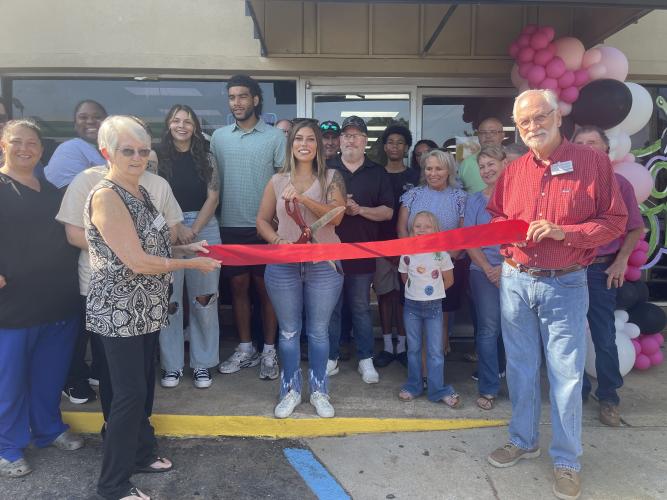 Surrounded by friends, family and local officials, Stephanie Mattox-Nation gets ready to cut the ribbon at the grand opening of The Local Spot, a new restaurant in Crawford, on Friday morning. The business, located at 1185 Athens Road, has a few unique appetizer options, such as Philly cheesesteak egg rolls and dill pickle and cream cheese bombs. (Lexie Shadix/The Oglethorpe Echo)